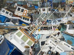 fisher boats piled on top of each other after a storm.