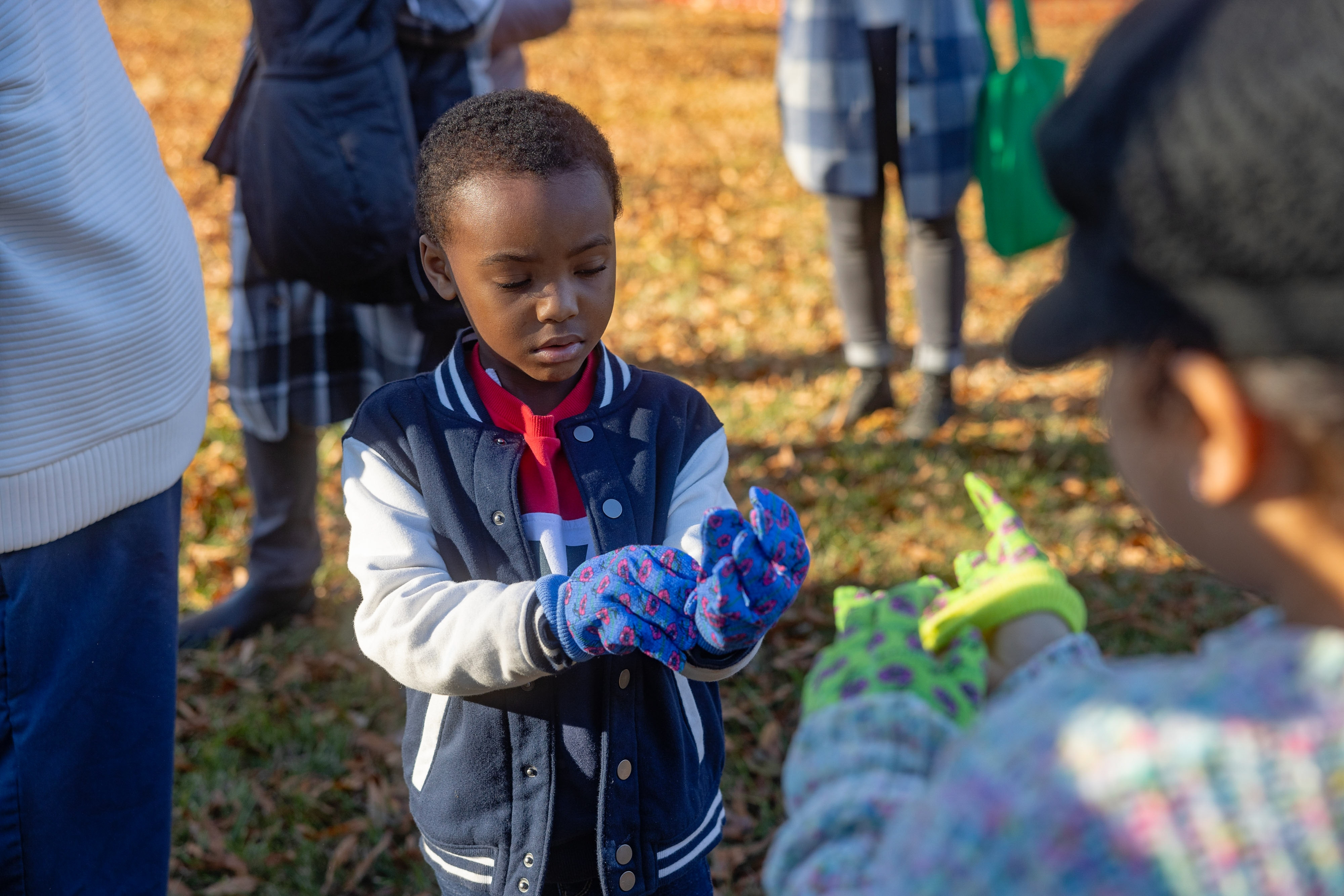 a child puts on garden gloves.
