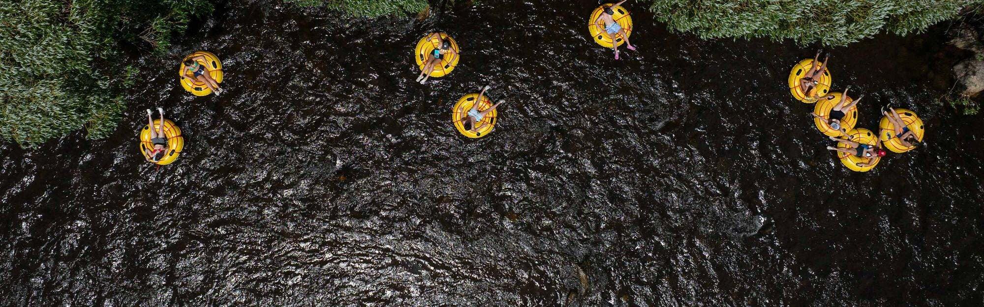people on yellow tubes float down the Yampa River.