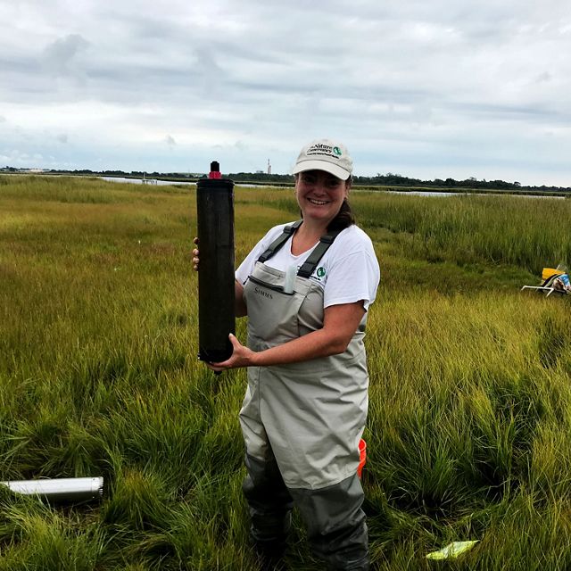 Nicole Maher poses with a salt marsh core sample.